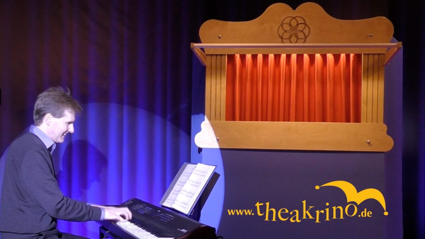 Joachim Gößler am E-Piano neben dem von ihm erfundenen 'theakrino'-Puppentheater